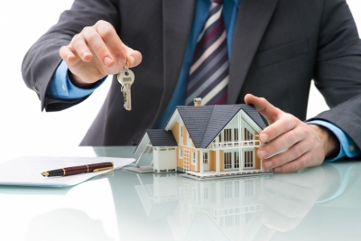 <p>Man holding house presenting keys depicting this section being about buying real estate.</p>